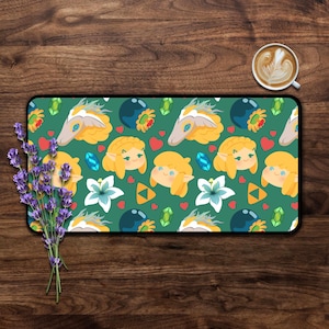 Peut inclure: Un tapis de bureau rectangulaire avec un motif répétitif sur fond vert foncé. Le design comprend des illustrations de personnages blonds aux oreilles pointues, des fleurs blanches, des cristaux bleus et verts, des cœurs rouges et des triangles orange.