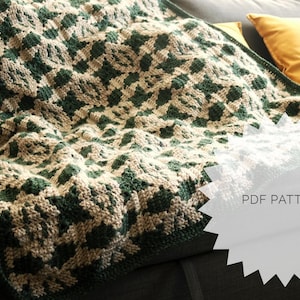 May include: A green and beige crochet blanket with a geometric pattern. The blanket is folded and draped over a couch. A white circle with the text "PDF PATTERN" is in the lower right corner of the image.