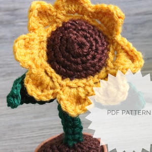 Pode incluir: Padrão de crochê para um girassol. O padrão inclui instruções para fazer um girassol de crochê com um centro marrom e pétalas amarelas. O girassol está sentado em um vaso marrom com folhas verdes.