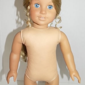 K&ouml;nnte beinhalten: Puppe mit blondem Haar, das in lockeren Locken gestylt ist, und blauen Augen. Die Puppe tr&auml;gt einen beigefarbenen Body. Der Hautton der Puppe ist hell. Die Puppe steht vor einem wei&szlig;en Hintergrund.