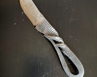 May include: A hand-forged steel cheese knife with a unique twisted handle and a serrated blade.