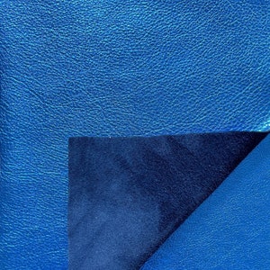 K&ouml;nnte beinhalten: Ein blaues Ledernotizbuch mit einer umgeklappten Ecke, die ein dunkelblaues Innere zeigt.