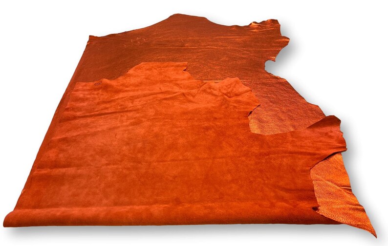 May include: A piece of orange suede leather. The leather is soft and supple, with a slightly textured surface.