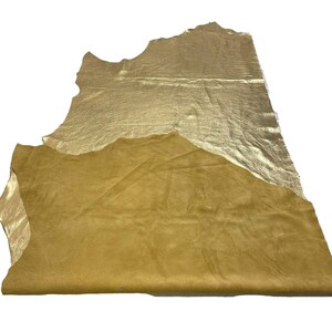 May include: A piece of gold leather with a suede backing. The leather is folded in half, showing both sides.