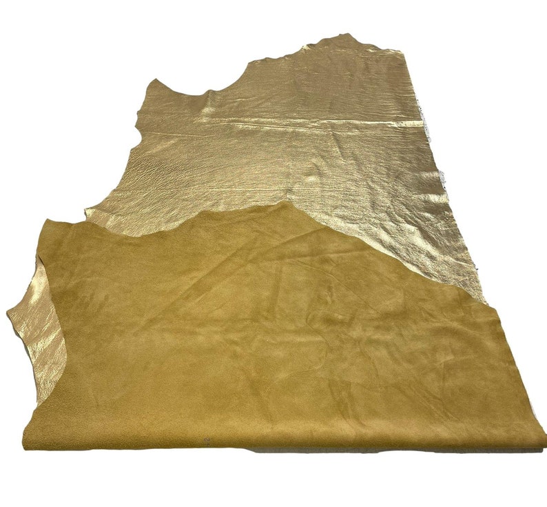 May include: A piece of gold leather with a suede backing. The leather is folded in half, showing both sides.