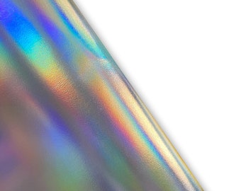 Op de afbeelding: Een close-up van iriserend holografisch papier met een zilveren basis en een regenboogkleurige glans. Het papier is over zichzelf gevouwen, waardoor een scherpe vouw ontstaat.