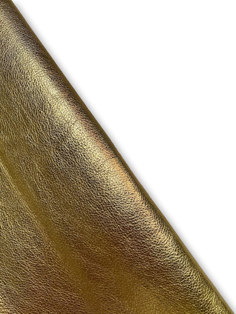 May include: A close-up of a piece of gold leather with a textured surface.