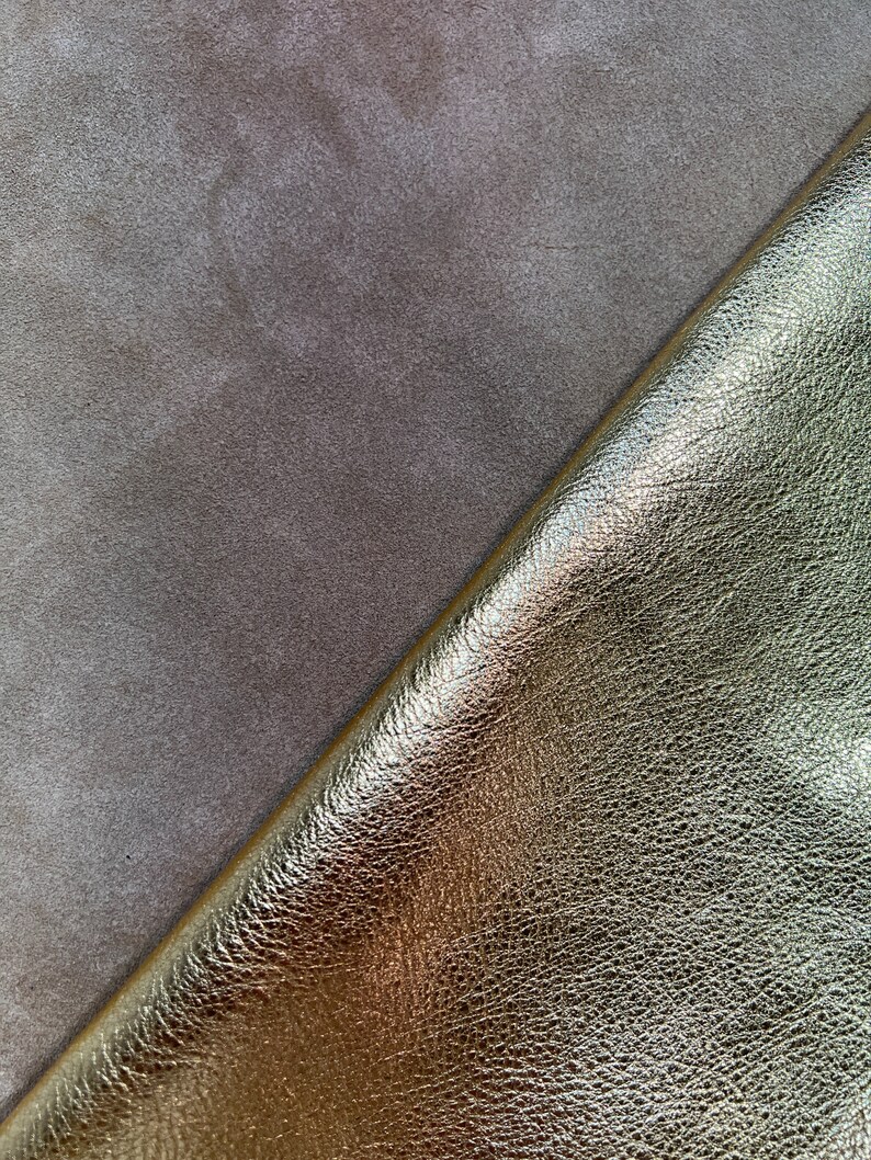 May include: Close-up of two pieces of leather. One piece is a light brown suede and the other is a gold metallic leather.