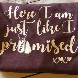 May include: Burgundy t-shirt with white text that reads "Here I am just like I promised xxx" with two white dog tags hanging from a chain that reads "Pitts".