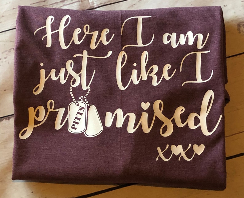 May include: Burgundy t-shirt with white text that reads "Here I am just like I promised xxx" with two white dog tags hanging from a chain that reads "Pitts".