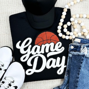 May include: Black sweatshirt with a white "Game Day" graphic and an orange basketball graphic.