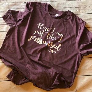 May include: Burgundy t-shirt with a gold glitter design that says "Here I am just like I promised xxx".