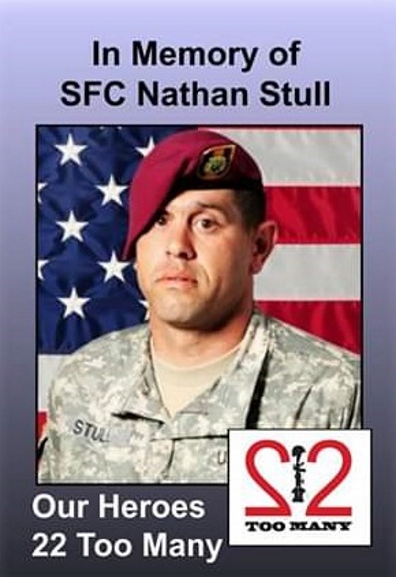 May include: A black and white photo of a soldier in uniform with a red beret. The soldier is standing in front of an American flag. The text "In Memory of SFC Nathan Stull" is at the top of the image. The text "Our Heroes 22 Too Many" is at the bottom of the image. There is a red logo with the number 22 and the text "Too Many" below it.