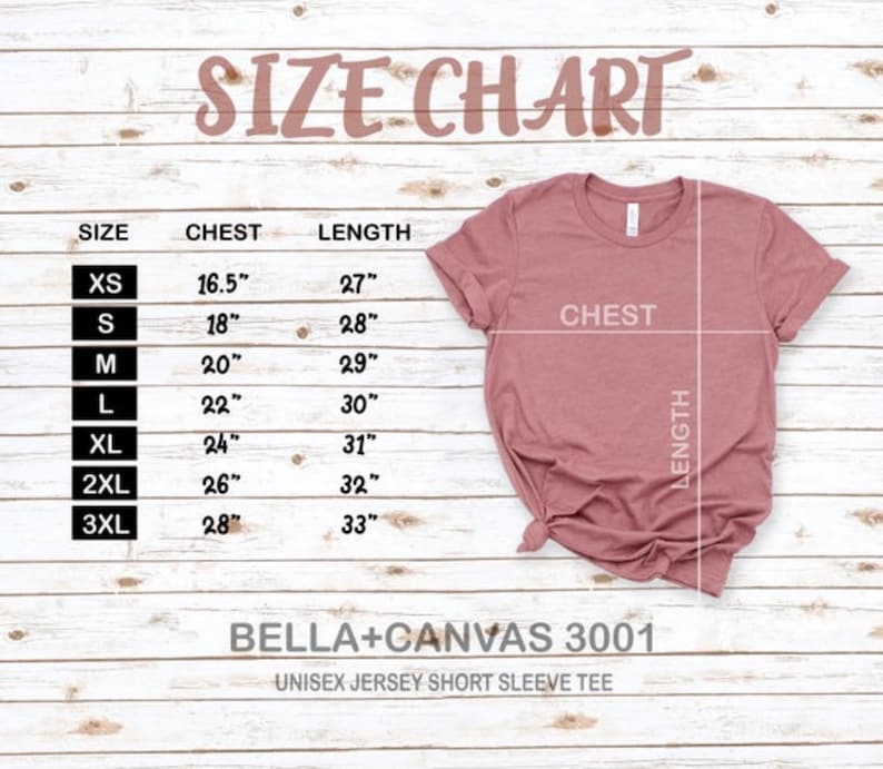 May include: Size chart for a unisex jersey short sleeve tee, showing chest and length measurements in inches for sizes XS to 3XL. The chart is printed on a light wood background.  The image also shows a pink t-shirt laid flat.