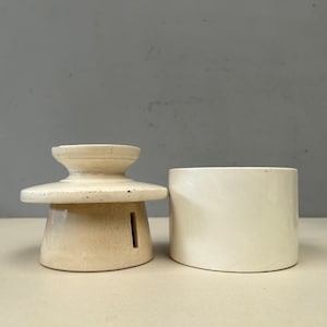 May include: A white ceramic butter dish with a lid. The lid has a small hole in the center. The dish is made of a smooth, white ceramic.
