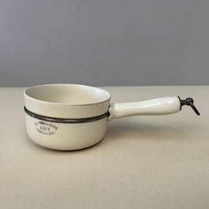 May include: White ceramic saucepan with a metal rim and a white handle. The saucepan has the text "La Culinilite GBV Brevete" printed on the side.