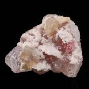 Pode incluir: Uma amostra mineral com um grupo de cristais. A base é rosa pálido e branca, com cristais de pêssego claro e rosa escuro. O fundo é preto. A amostra é provavelmente uma amostra geológica.