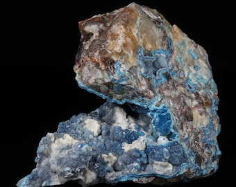 May include: A large, rough, blue and white mineral specimen with a crystalline structure. The mineral has a blue outer layer and a white interior with blue crystals.