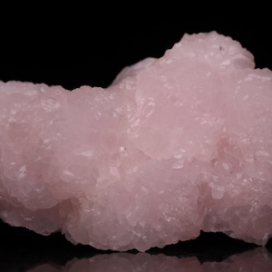 May include: A cluster of pink, rose quartz crystals with a rough, textured surface.