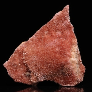 May include: A large, rough, pink and white mineral specimen with a textured surface. The mineral has a crystalline structure and appears to be a cluster of small crystals.