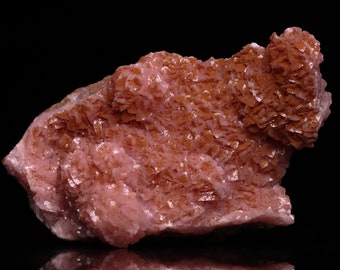 Può includere: Un grande esemplare minerale rosa e marrone con una texture ruvida e cristallina. Il minerale ha una forma naturale e organica ed è un bellissimo esempio di cristallo naturale.