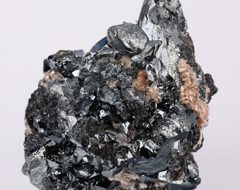 Op de afbeelding: Een cluster van zwarte en zilveren hematietkristallen met een metallic glans. De kristallen zijn scherp en hoekig, en sommige hebben een licht iriserende kwaliteit.