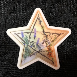 May include: A five-pointed star-shaped sticker with a wooden background. The sticker features a glass bottle, lavender flowers, and orange flowers, all intertwined with vines.