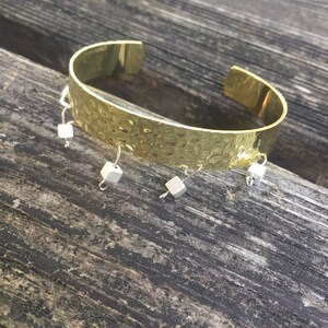 Gold cuff metal bracelet with silver square bead dangle