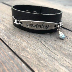 Black leather bracelet with Wanderlust charm