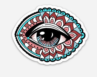 May include: A stylized eye with a blue iris and black pupil, surrounded by a mandala pattern in shades of red, pink, and blue.