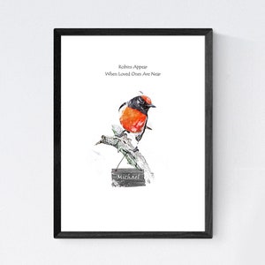 May include: A framed print with a watercolor illustration of a red-breasted robin perched on a branch. The print features the text "Robins Appear When Loved Ones Are Near" and a sign that reads "Michael".