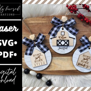 May include: Three laser cut wooden ornaments with black and white buffalo check ribbon. The ornaments are round and feature a farmhouse theme. One ornament says "Home Sweet Home 37122 2022", another says "Wilson Homestead 2022", and the third says "Home Sweet Home Gladwell, Tx 2022".