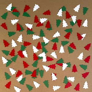 May include: A brown background with a scattering of green, red, and white paper Christmas tree cutouts.