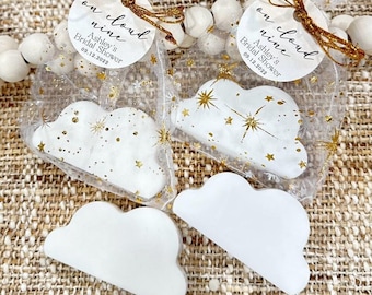Puede incluir: Favores en forma de nube con purpurina dorada y estrellas, empaquetados en bolsas de organza transparentes con una etiqueta redonda que dice "on cloud nine" y "Ashley's Bridal Shower 09.12.2022".