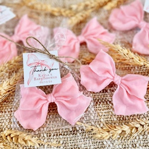 May include: Pink satin bows in clear cellophane bags with a thank you tag that reads "Thank you Kayla's Baby Shower 08/12/24".