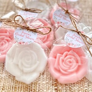 May include: Favor boxes filled with pink and white rose-shaped soaps, tied with twine and decorated with round tags that say "Jessica's Bridal Shower".