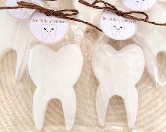 May include: White tooth-shaped soap favors with a brown twine bow and a round tag that says "Dr. Allen Villiers" with a cartoon tooth and a smiley face.