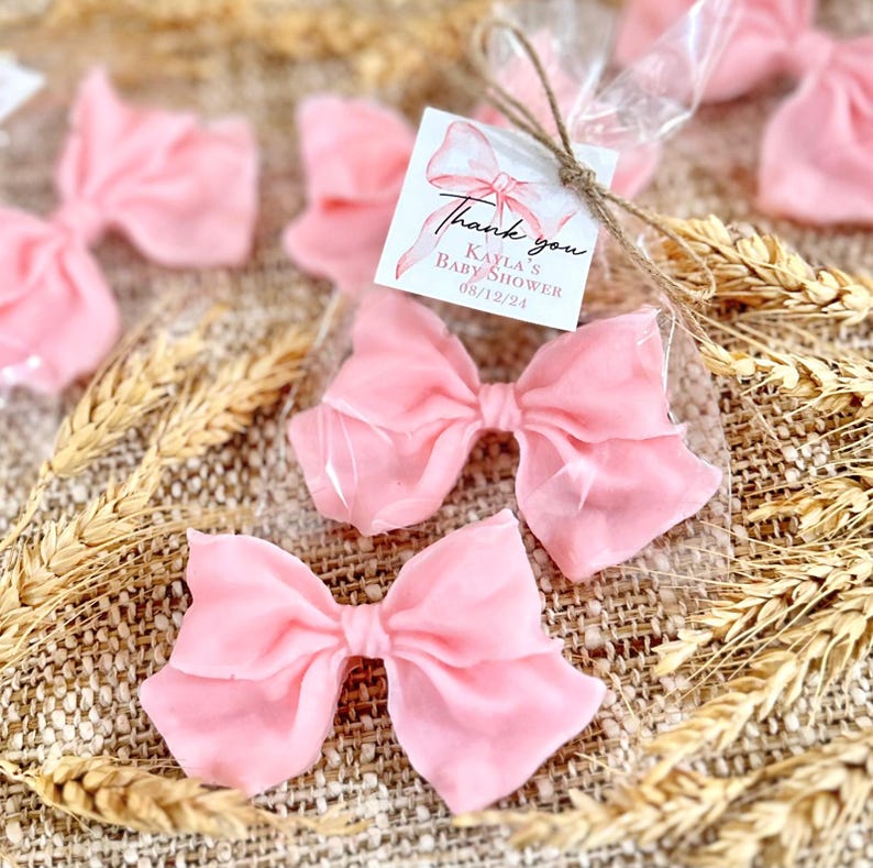 May include: Pink satin bows packaged in clear cellophane bags with a thank you tag that reads "Thank you Kayla's Baby Shower 08/12/24".