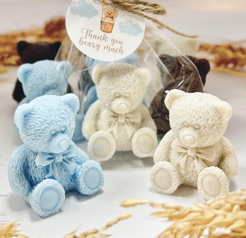 May include: Four small teddy bear shaped soaps, two are white, one is light blue, and one is brown. The soaps are packaged in clear cellophane bags with a small tag that says "Thank you beary much".