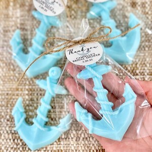 May include: Light blue anchor-shaped soap favors wrapped in clear cellophane bags with a brown twine bow and a round white tag that says "Thank you, Camille's Bridal Shower, 5.20.23"