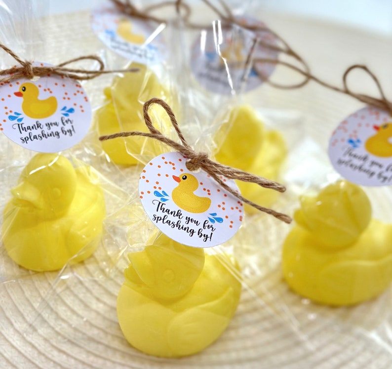 May include: Yellow rubber duck bath toys wrapped in clear cellophane bags with a brown twine bow and a round tag that says "Thank you for splashing by!" with a yellow rubber duck and blue raindrops on it.
