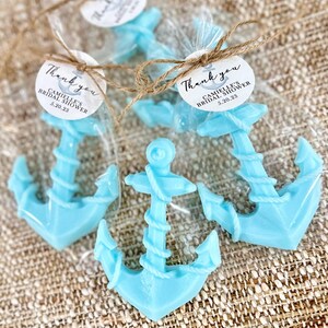 May include: Three blue anchor-shaped favors in clear cellophane bags tied with twine and a round tag that says "Thank you, Camille's Bridal Shower, 5.20.23".