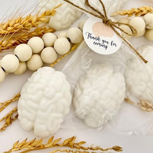 May include: White brain-shaped favors wrapped in clear cellophane bags with a brown twine bow and a round white tag that says "Thank you for coming".