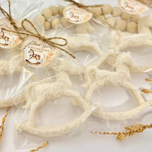Puede incluir: Favores de caballo de balanc&iacute;n blanco en bolsas de celof&aacute;n transparentes atadas con cordel y una peque&ntilde;a etiqueta de agradecimiento que dice "Gracias Blake's Baby Shower 01.17.2023".