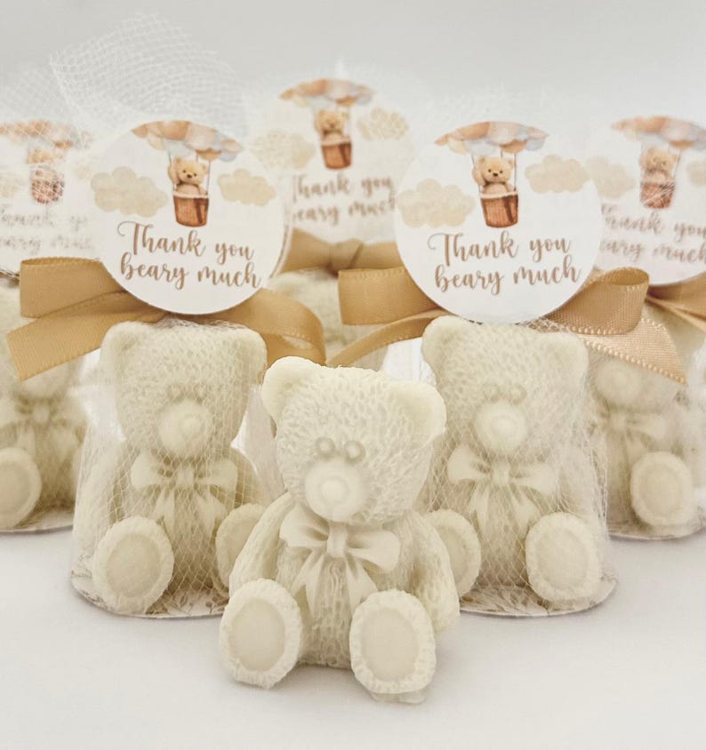 May include: Set of small white teddy bear favors with a brown ribbon and a round tag that says "Thank you beary much" with a hot air balloon illustration.