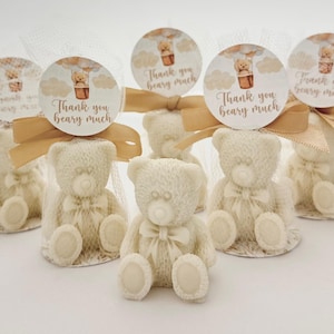 May include: Five small white teddy bear figurines with brown bows are packaged in clear cellophane bags with gold ribbon and a round tag that says "Thank you beary much".