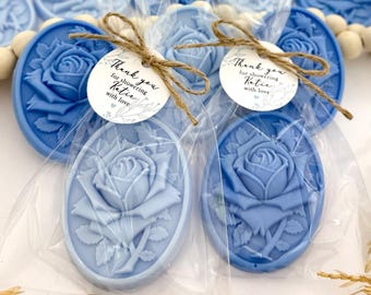 May include: Blue rose-shaped soap favors wrapped in clear cellophane bags with a thank you tag that reads "Thank you for showering Katie with love".