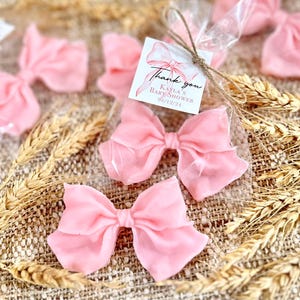 May include: Pink satin bows packaged in clear cellophane bags with a thank you tag that reads "Thank you Kayla's Baby Shower 08/12/24".