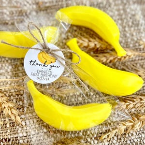 May include: Thank you favor bags with yellow banana shaped soap and a round tag that says "thank you... Daniel's First Birthday 9/27/24"