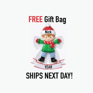 May include: A Christmas ornament featuring a child dressed in winter attire, with the name "Nick" on the hat. The ornament has a green coat, red scarf, and blue pants. The text "YEAR" is on a banner.